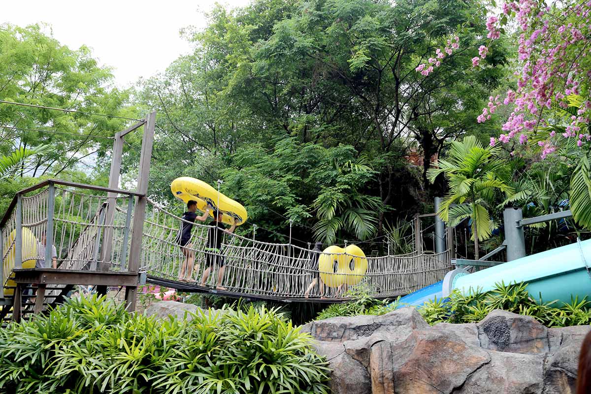 A group of friends carrying their dual float while crossing the bridge, heading to Primeval, Sunway Lagoon